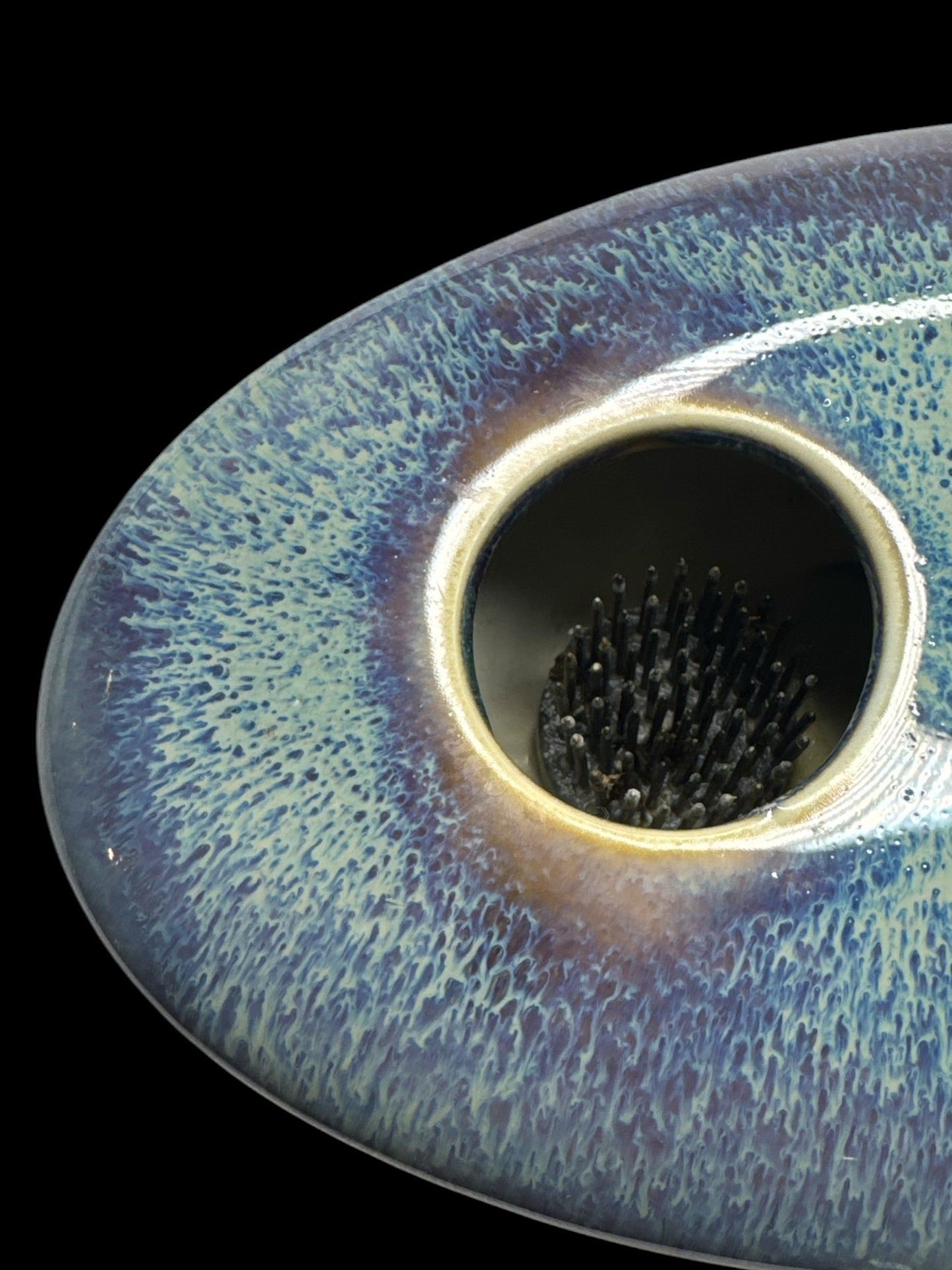 Actual Product Image - Close-up of a textured ceramic object with a central hole on a black background